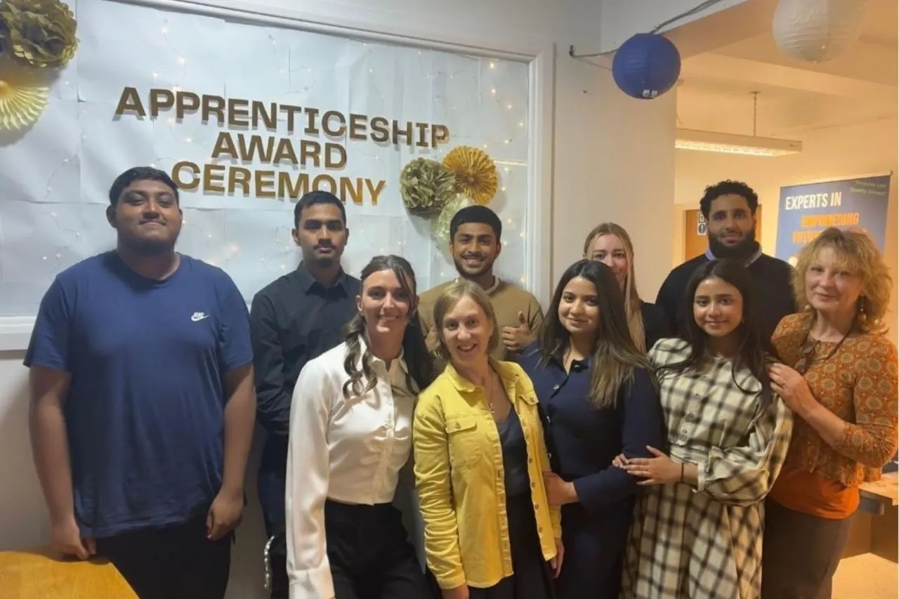 A group posing together in front of the NextStep Apprenticeship Award Ceremony banner.